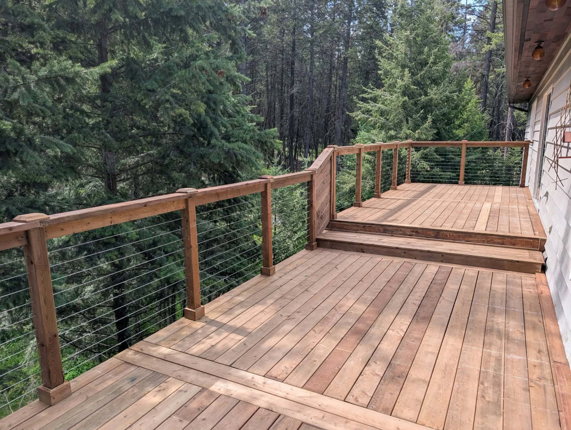 Multi-level cedar deck with cable railing overlooking the forest