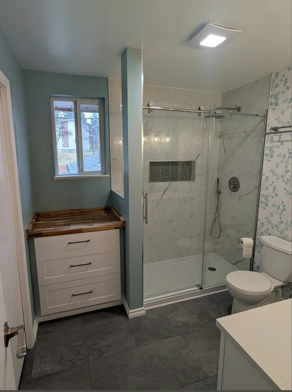 Bathroom remodel with glass shower and custom dresser