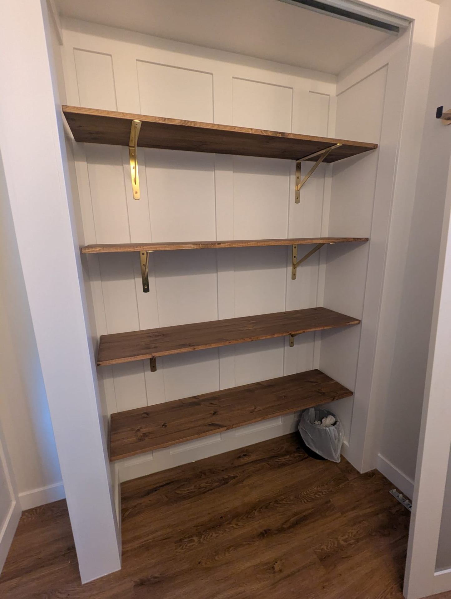 Custom closet with wood shelves and brass brackets